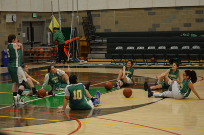 Geyserville players stretch on the court  with basketballs at their feet